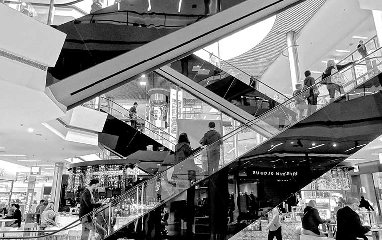 zwart-wit foto van roltrappen in een winkelcentrum. 