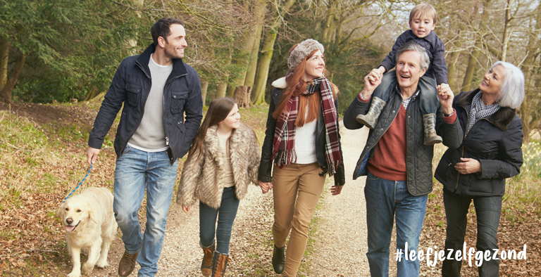 fitte familie in het bos. Kinderen, vader, moeder, opa en oma, wandelen met hond.